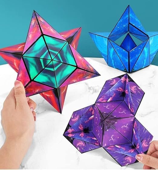 A photo of a boxed product called the “Changeable Magnetic Magic Cube.” The cube is displayed inside a unique packaging that emphasizes its geometric, triangular folding structure. The visible part of the cube has a vibrant, abstract blue design resembling swirling ocean or sky patterns. The box features various marketing phrases. The front side displays the name in bold white font: “Magic Cube,” with "Changeable" in red and "magnetic" in blue, highlighting its changeable and magnetic nature. The right side